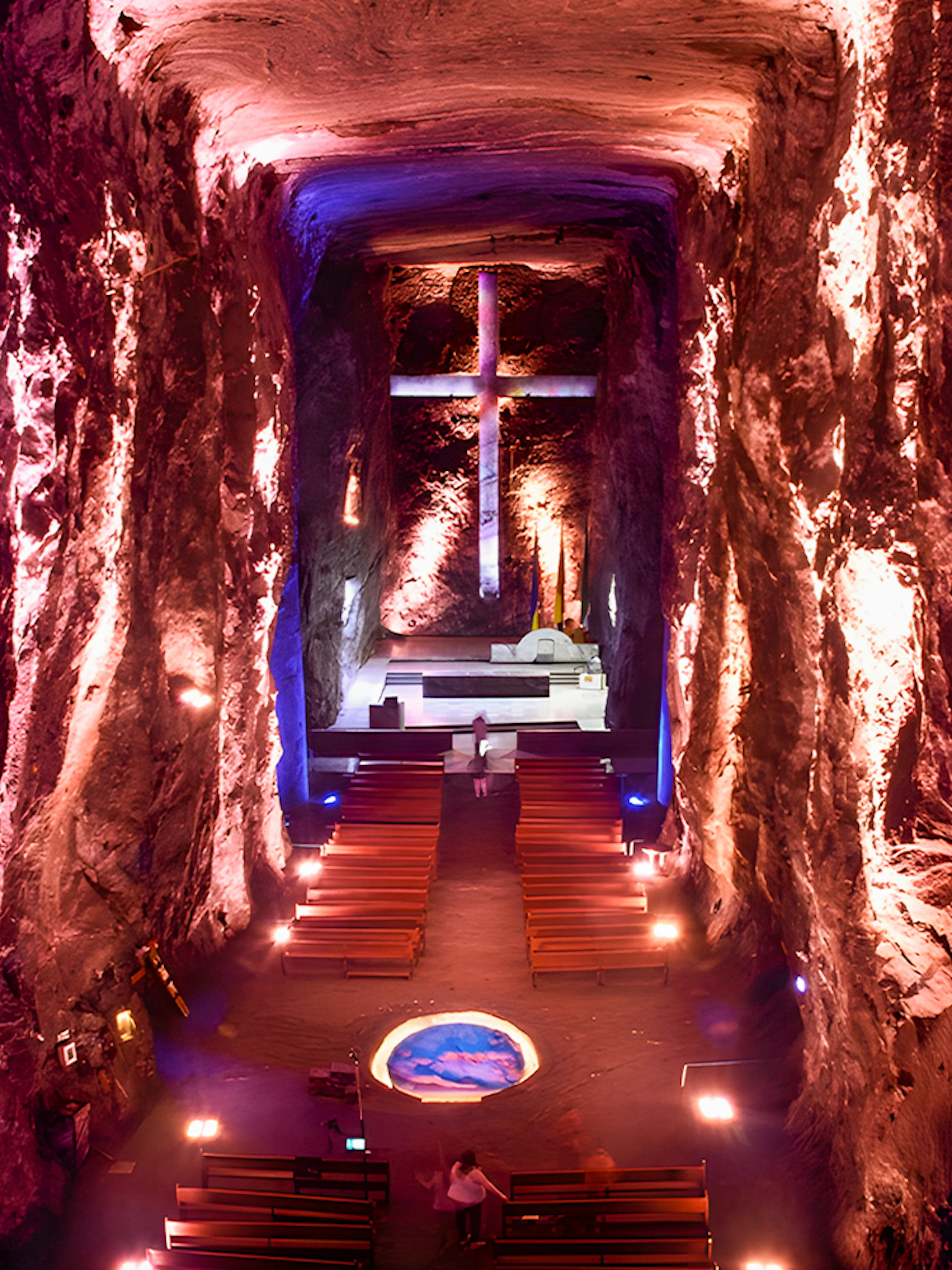 Salt Cathedral of Zipaquirá interior with illuminated cross and seating.