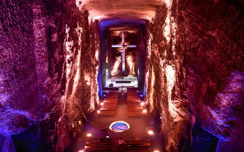 Salt Cathedral of Zipaquirá interior with illuminated cross and seating.