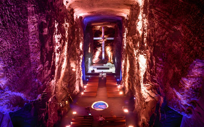 Salt Cathedral of Zipaquirá interior with illuminated cross and seating.