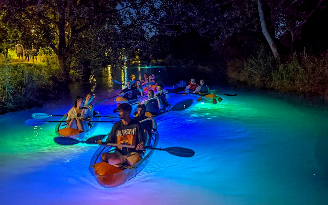 Paddlers on illuminated SUP boards during a night glow tour in Split.