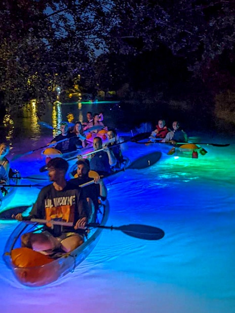 Paddlers on illuminated SUP boards during a night glow tour in Split.