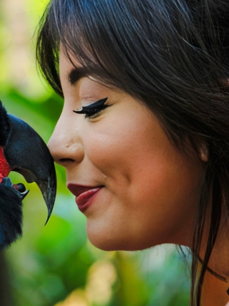 Tourist interacting with a parrot at Lombok Wildlife Park.