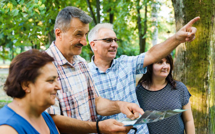 Tour guide pointing out landmarks to tourists in a forest setting.