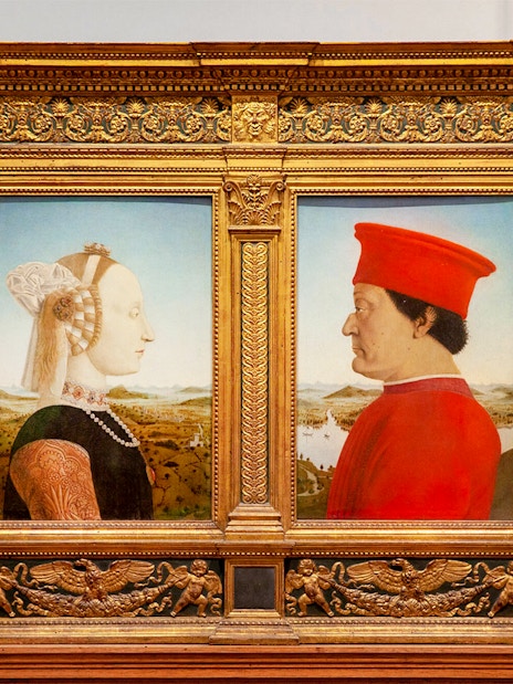 Portraits of a man and woman in ornate frames at Uffizi Gallery, Florence.