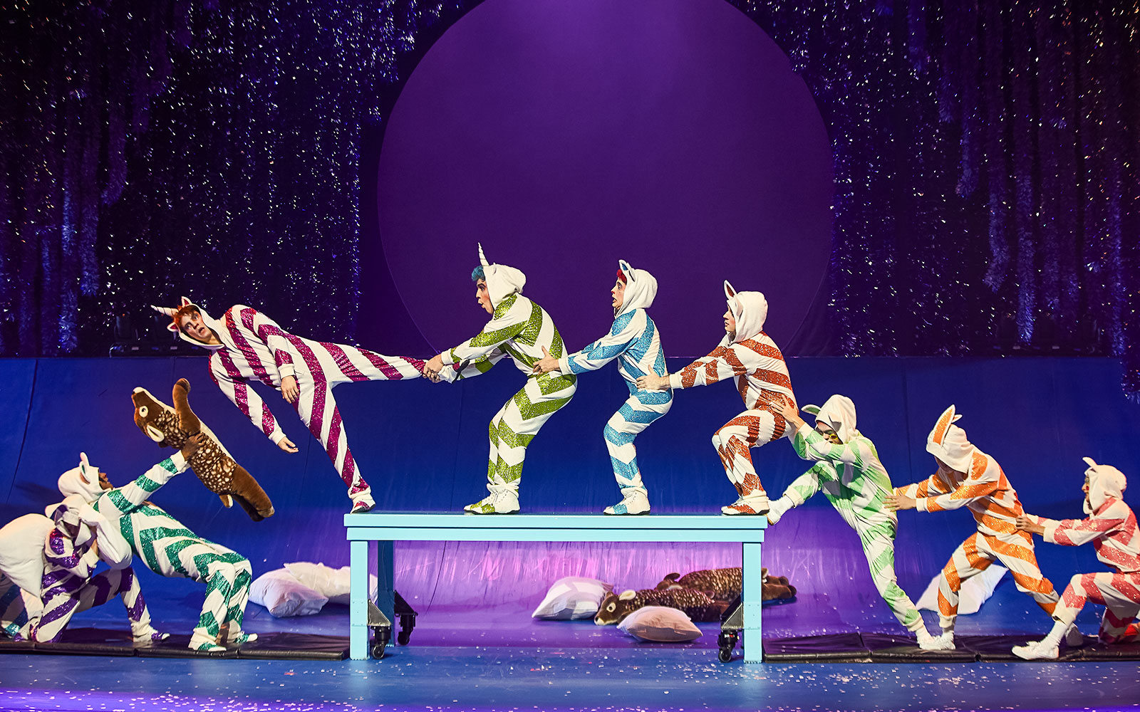 Performers in colorful costumes during Cirque du Soleil's 'Twas The Night Before stage show.