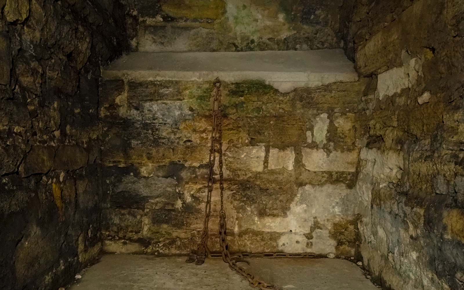 Narrow stone prison cell with chains in Castel Sant'Angelo, Rome.