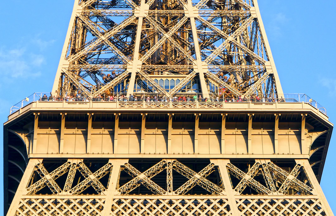 Eiffel Tower viewing platform with visitors during guided elevator tour in Paris.