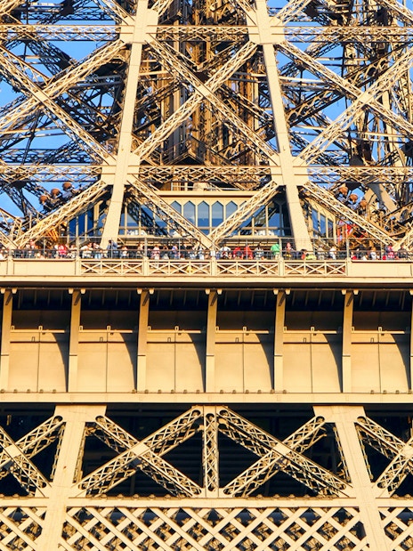 Eiffel Tower viewing platform with visitors during guided elevator tour in Paris.