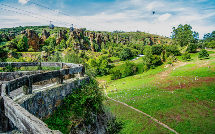 Cable cars over lush landscape in Cabárceno Nature Park, Spain.