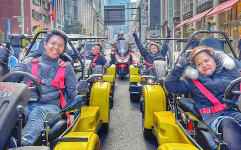 Tourists in go-karts on Tokyo street during landmarks tour.