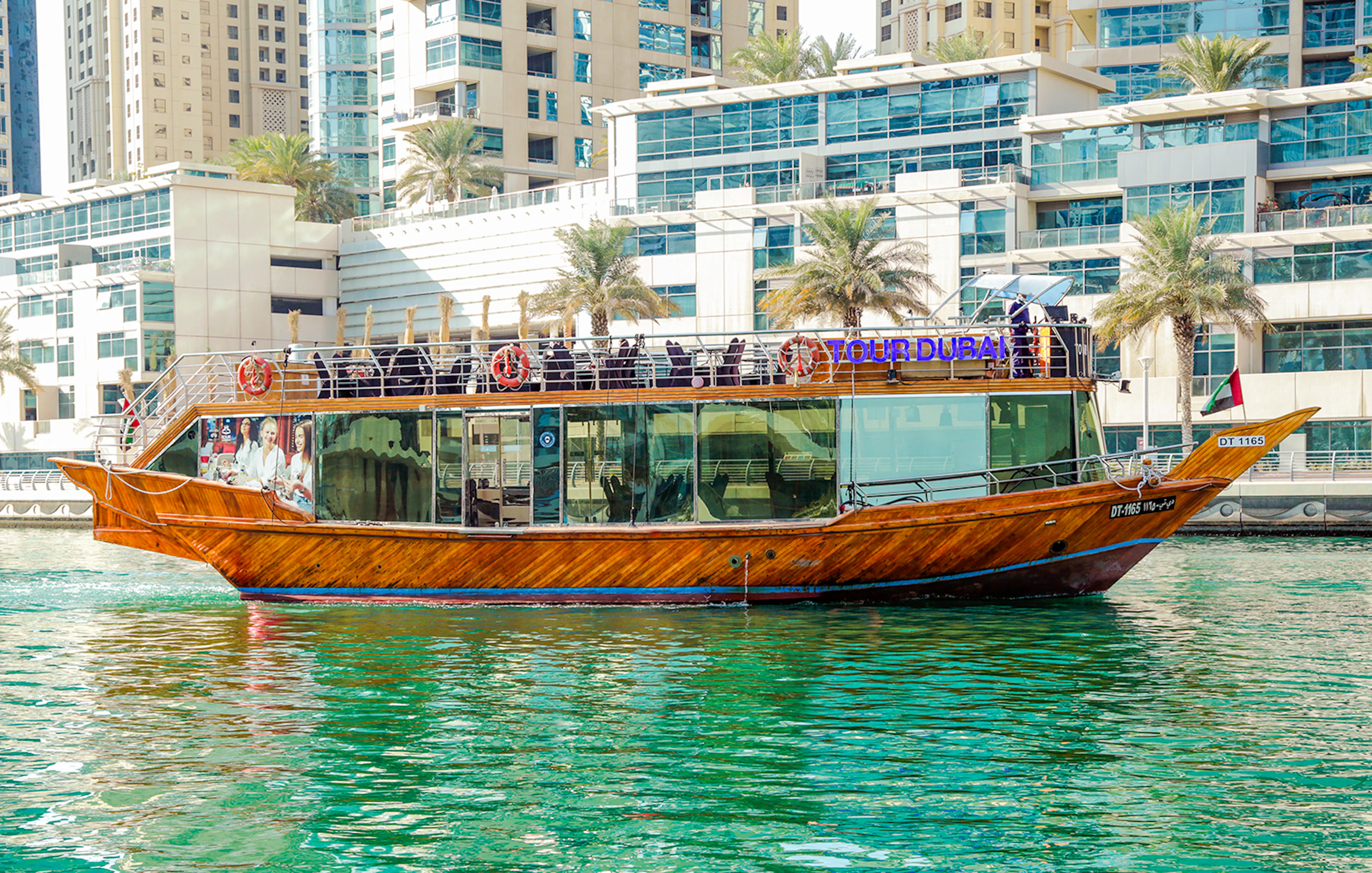 Dhow cruise on Dubai Creek with cityscape backdrop.