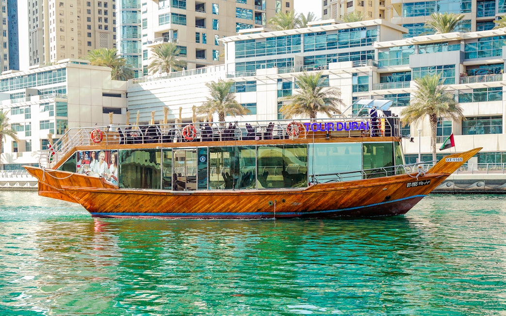 Dhow cruise on Dubai Creek with cityscape backdrop.