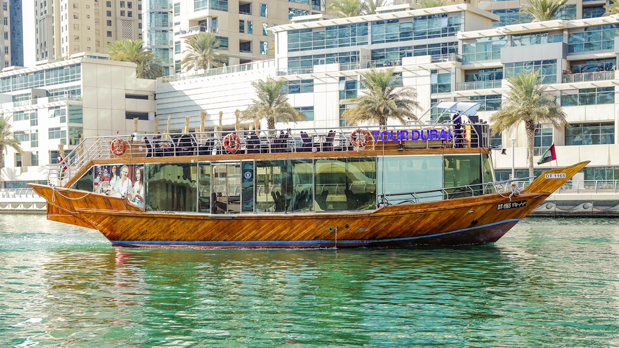 Dhow cruise on Dubai Creek with cityscape backdrop.