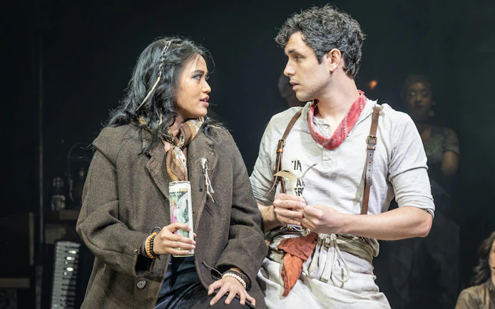 Actors performing a scene from Hadestown on West End stage.