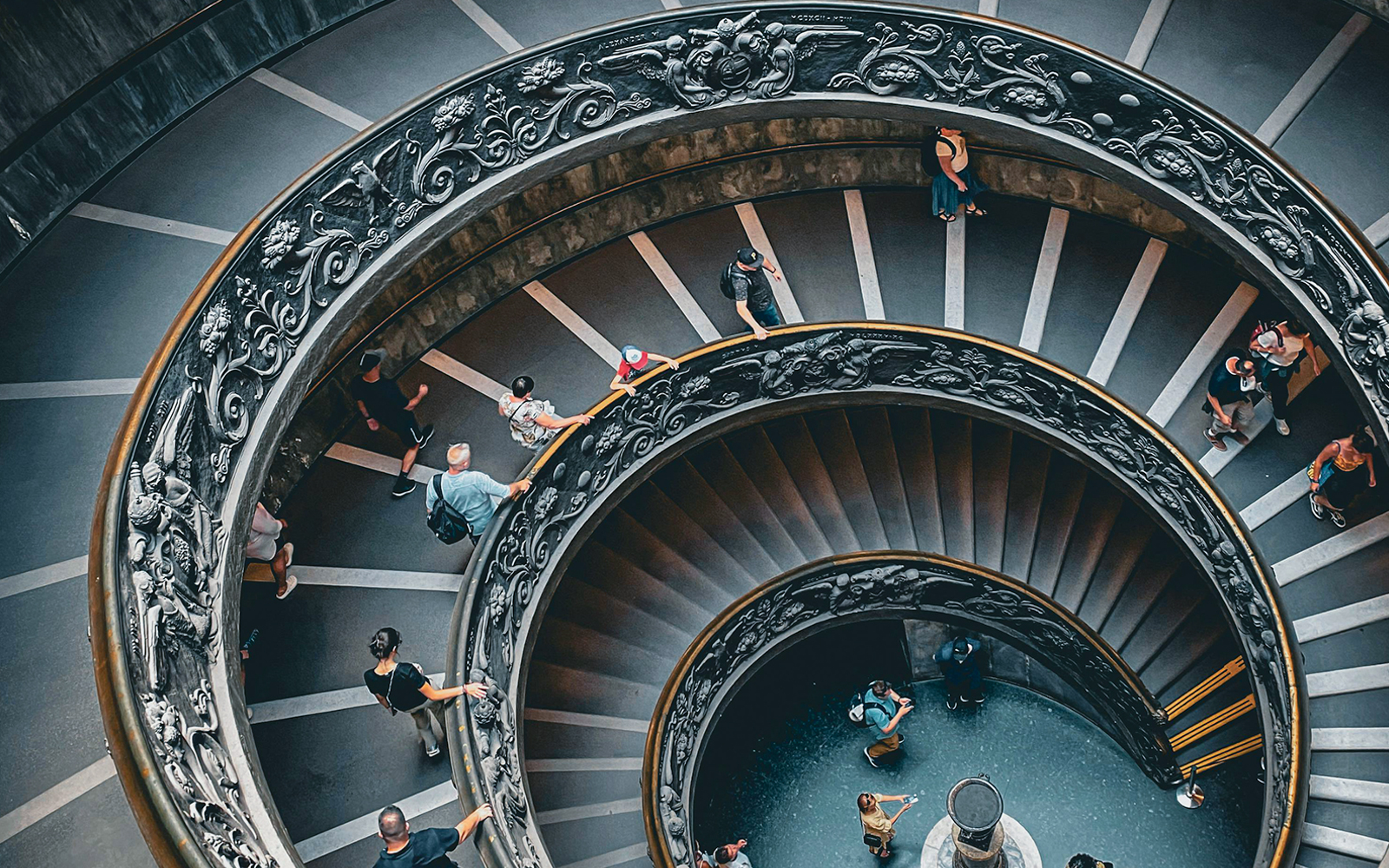 Vatican Museum spiral staircase with visitors, part of private tour experience.