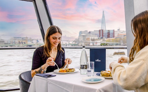 Dining on Thames River cruise with view of The Shard in London.
