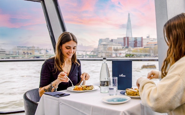 Dining on Thames River cruise with view of The Shard in London.