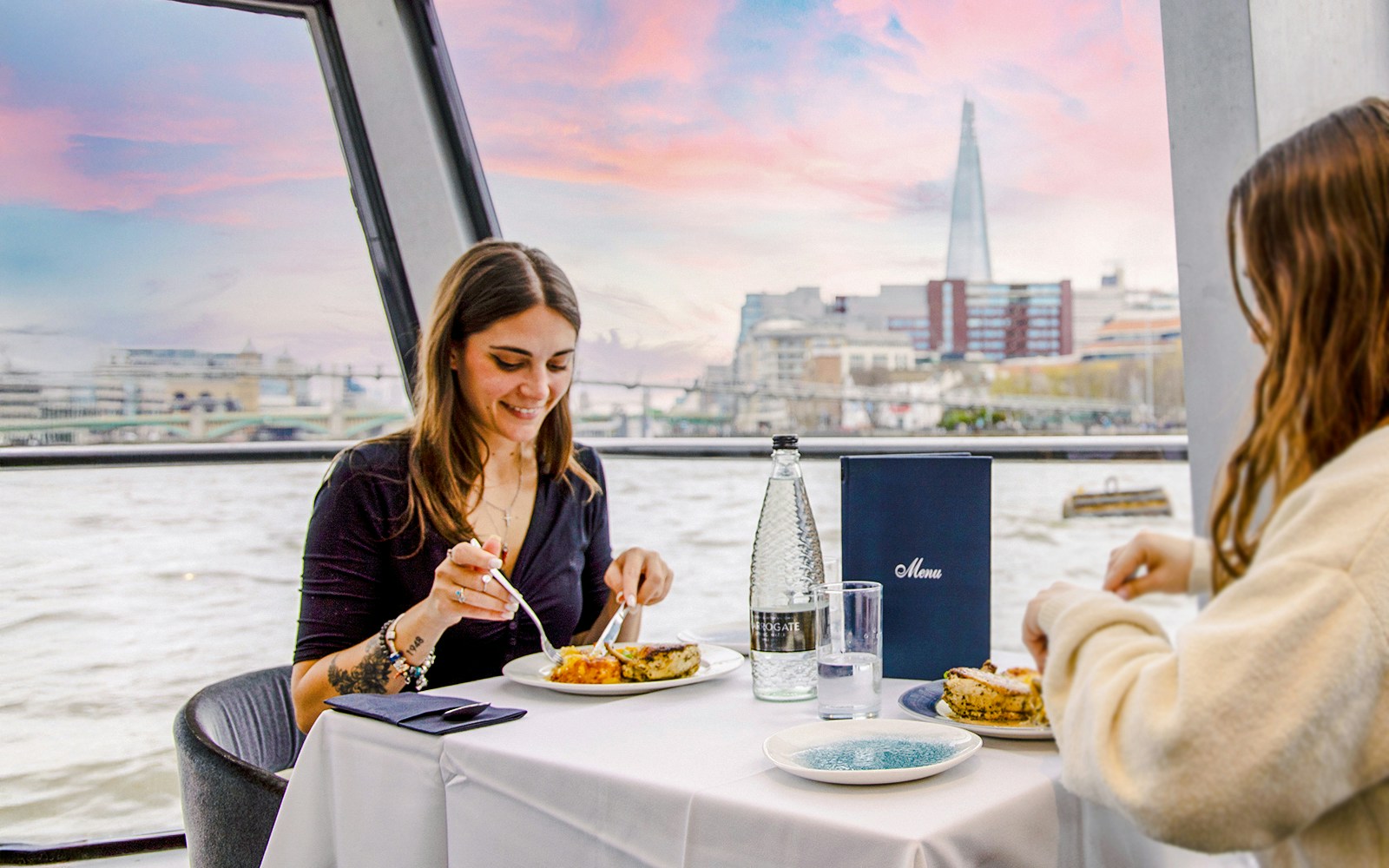 Dining on Thames River cruise with view of The Shard in London.