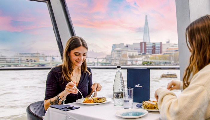 Dining on Thames River cruise with view of The Shard in London.