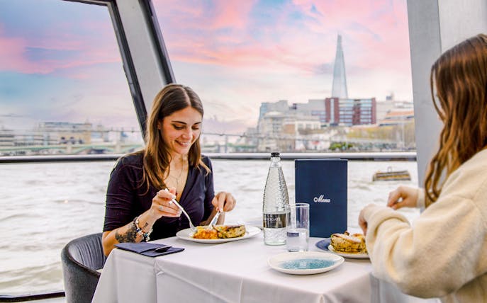 Dining on Thames River cruise with view of The Shard in London.
