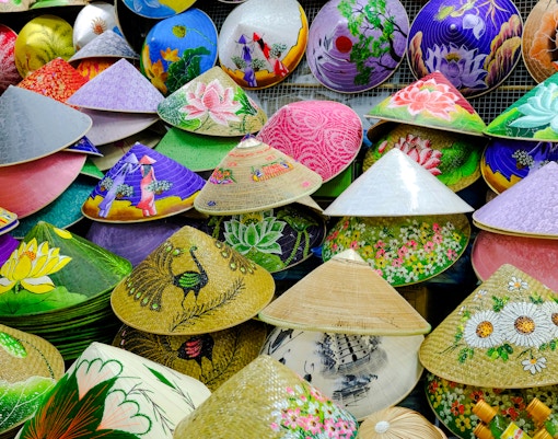 Colorful conical hats with floral and scenic designs at Dong Ba Market, Hue, Vietnam.