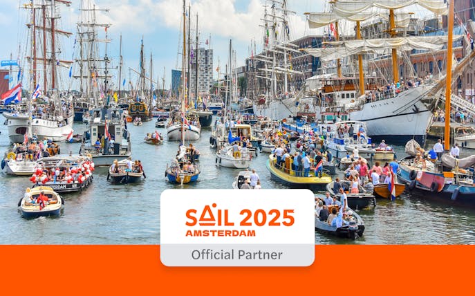 Crowded canal with boats and tall ships during SAIL Amsterdam 2025 event.