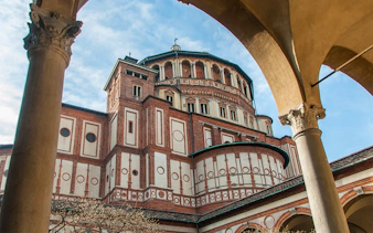 Santa Maria delle Grazie church exterior in Milan, Italy, viewed through archway.