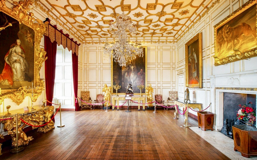 Warwick Castle interior with ornate paintings and chandelier.