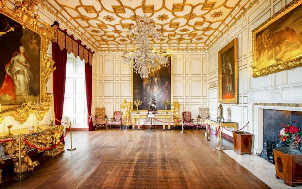 Warwick Castle interior with ornate paintings and chandelier.