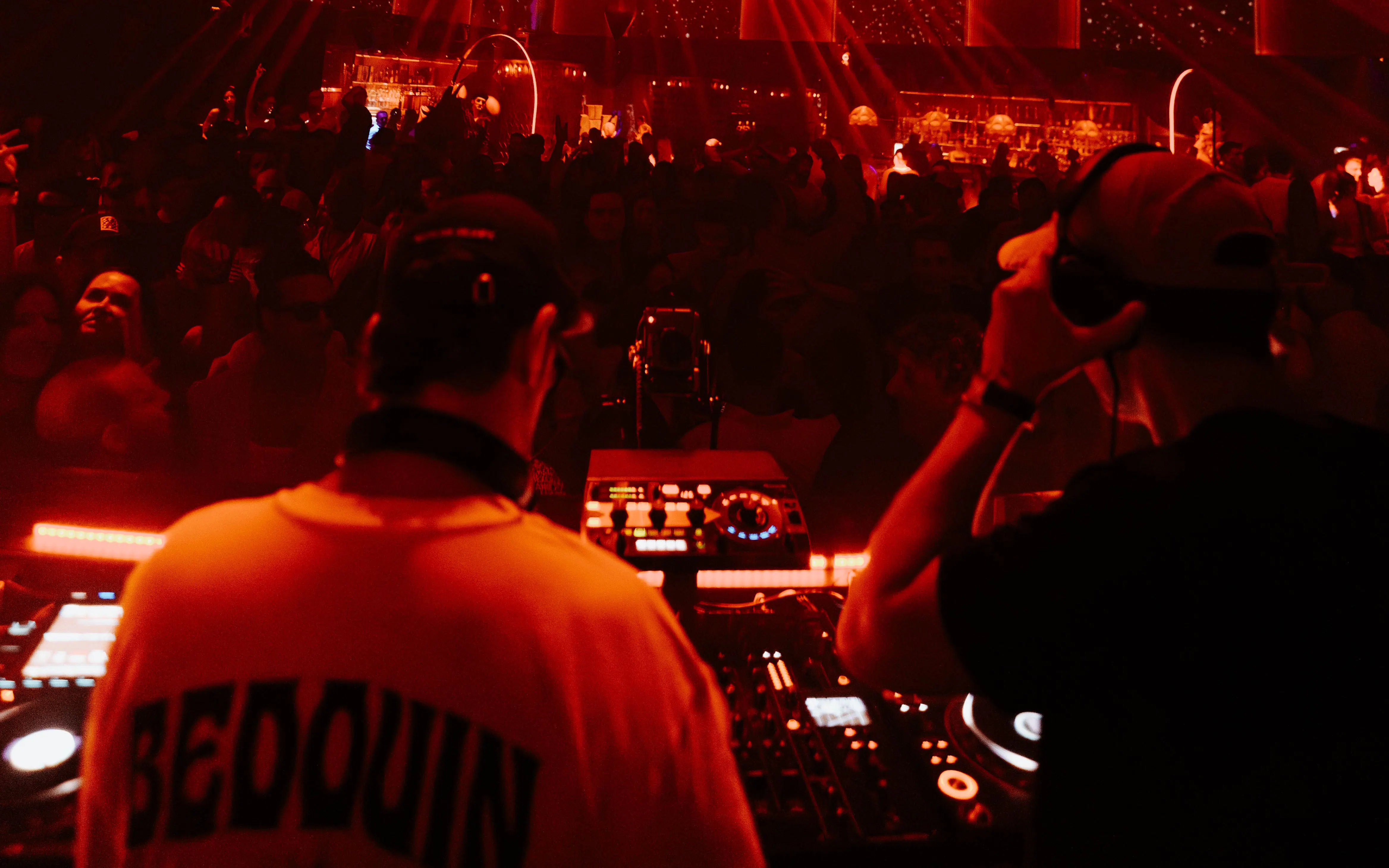 DJ performing at Club Chinois, Ibiza with vibrant crowd and lighting.