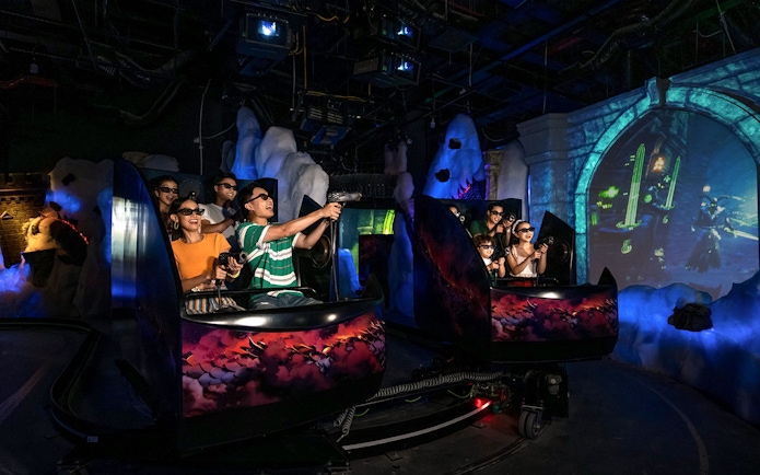 Visitors enjoying VR games at VinWonders in a themed indoor ride.
