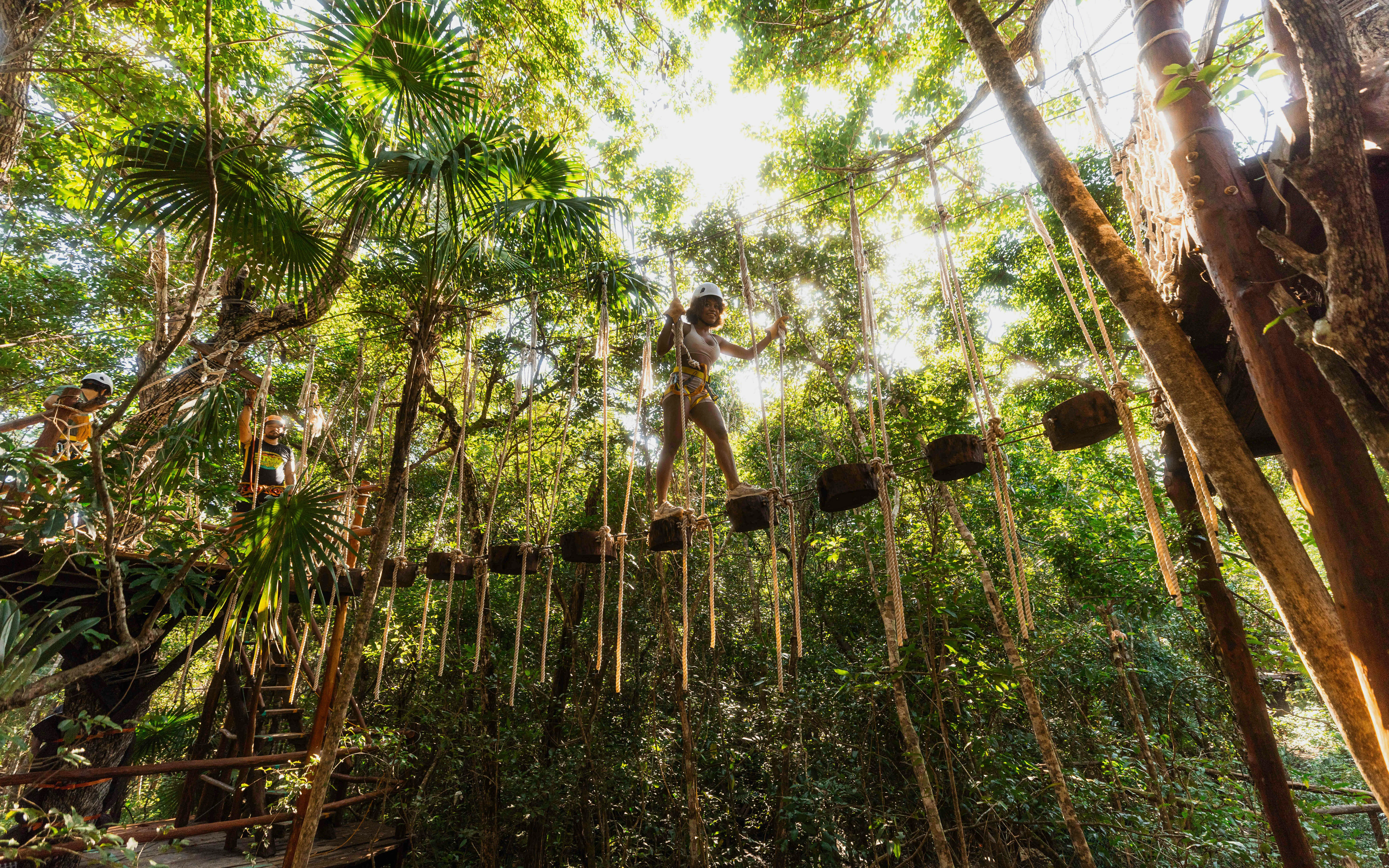 Person crossing a rope bridge in Cancun Extreme Adventuring Park.