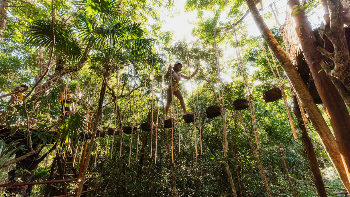 Person crossing a rope bridge in Cancun Extreme Adventuring Park.