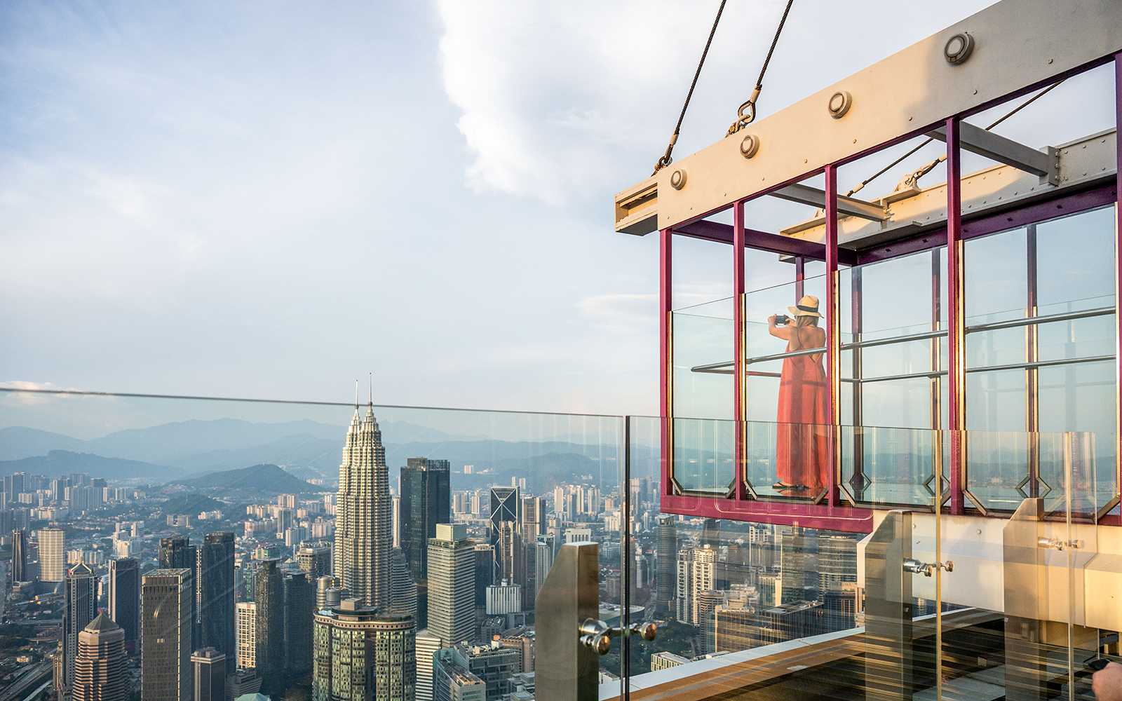 Tourist photographing cityscape from Kuala Lumpur Tower Glass Box.