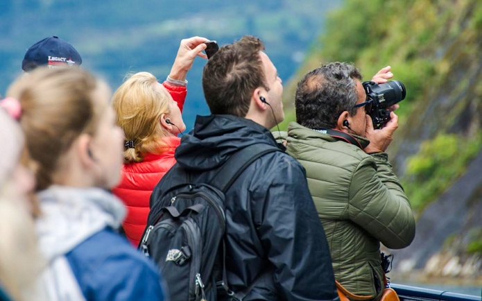 Tourists photographing scenery on Geiranger Silent Fjord Cruise.