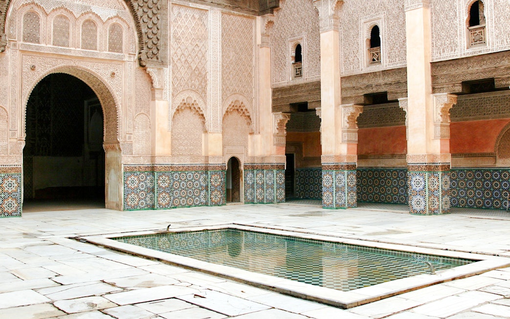Madrasa Ben Youssef courtyard with intricate tilework and central reflecting pool, Marrakech.