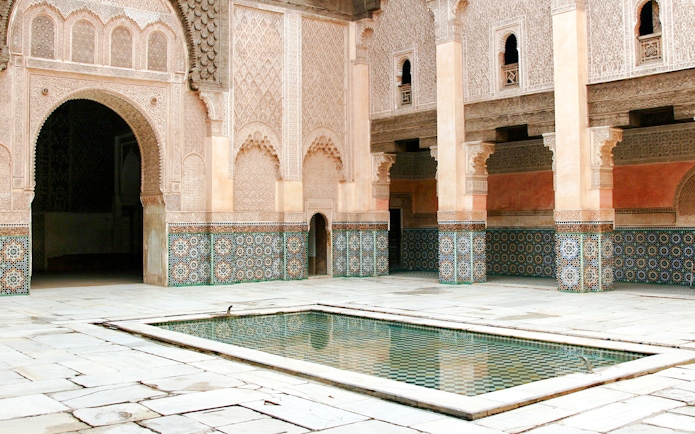 Madrasa Ben Youssef courtyard with intricate tilework and central reflecting pool, Marrakech.