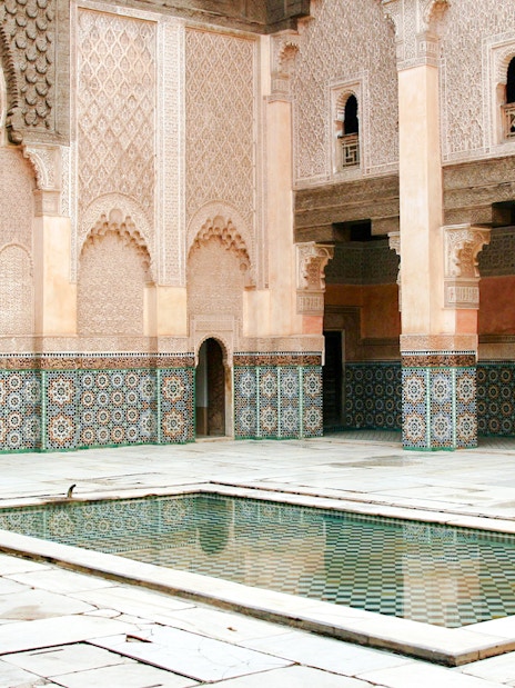 Madrasa Ben Youssef courtyard with intricate tilework and central reflecting pool, Marrakech.