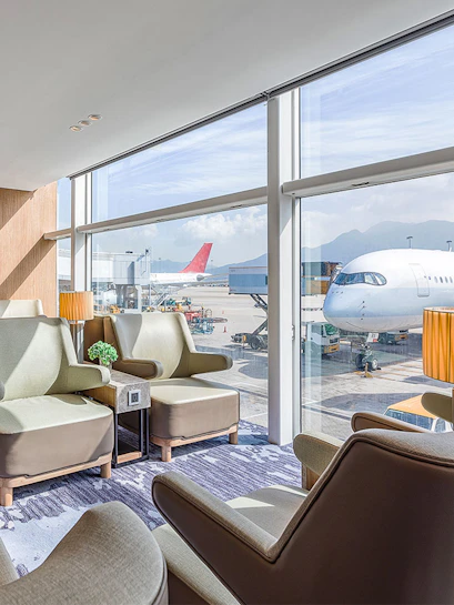 Plaza Premium Lounge Hong Kong with airport runway view and seating area.