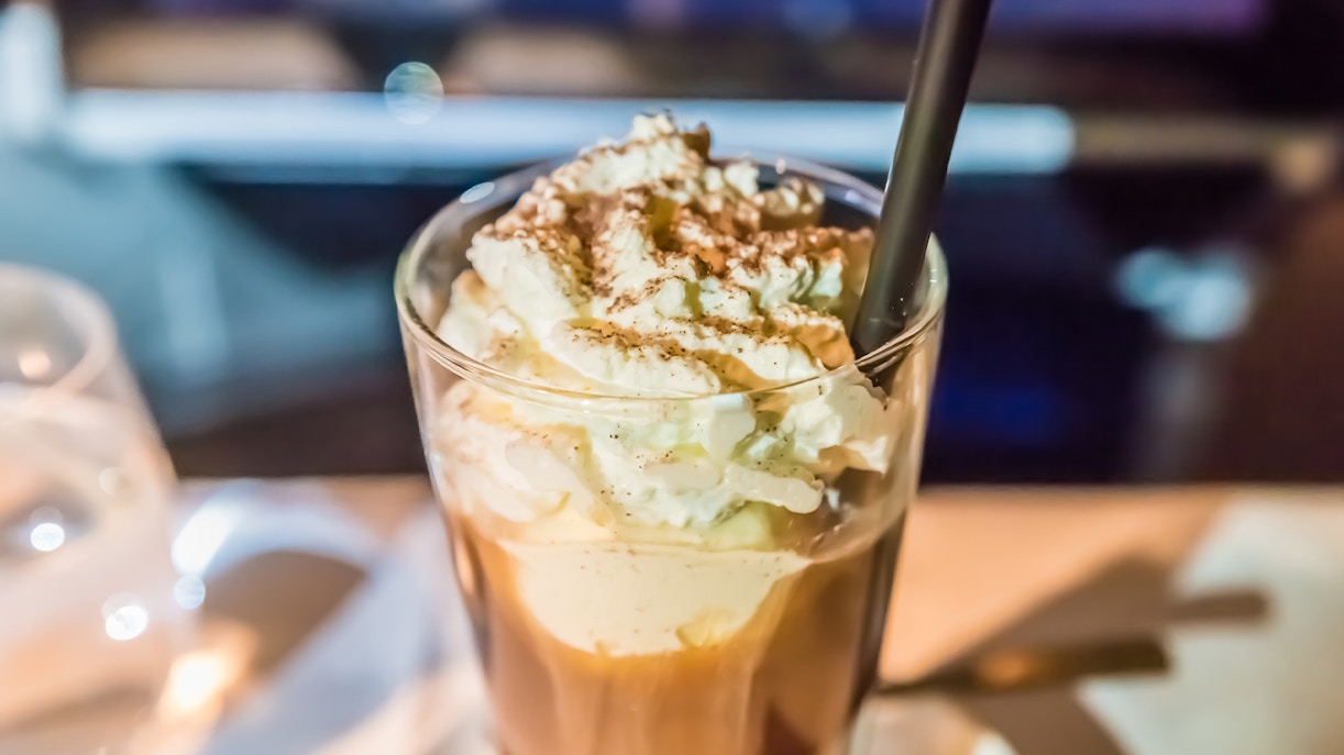 Viennese coffee topped with whipped cream and cocoa powder in a glass.