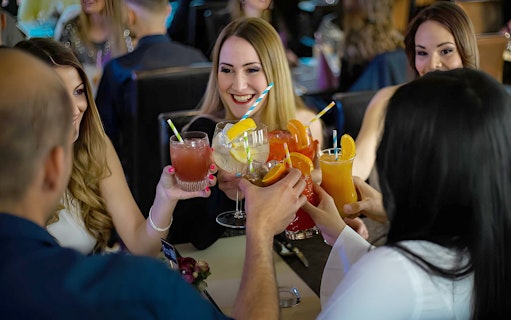 Guests enjoying cocktails on a Budapest Danube cruise with live music.