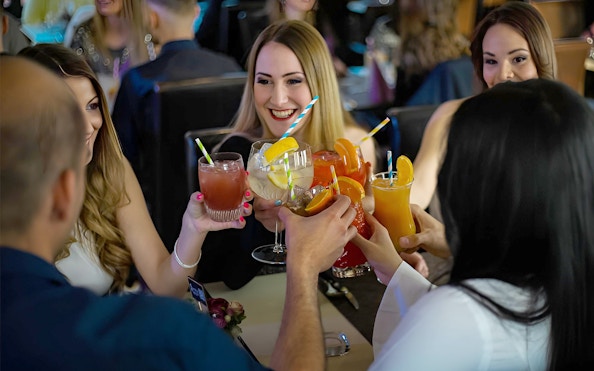 Guests enjoying cocktails on a Budapest Danube cruise with live music.