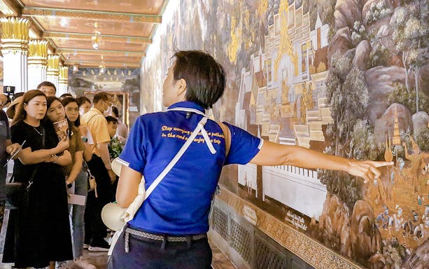Tour guide explaining mural at Wat Phra Kaew, Grand Palace, Bangkok.