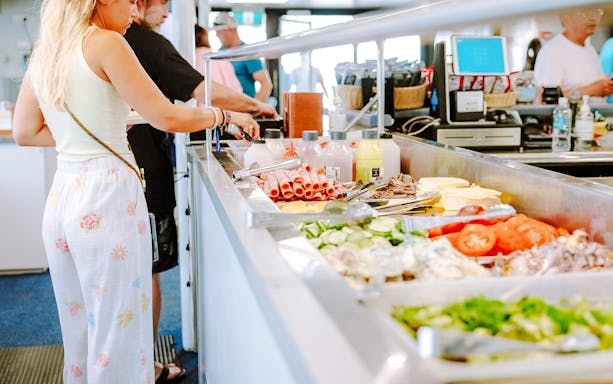 Buffet lunch setup on a Great Barrier Reef cruise with fresh vegetables and meats.