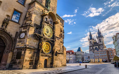 Astronomical Clock Tower in Prague with Tyn Church in the background.