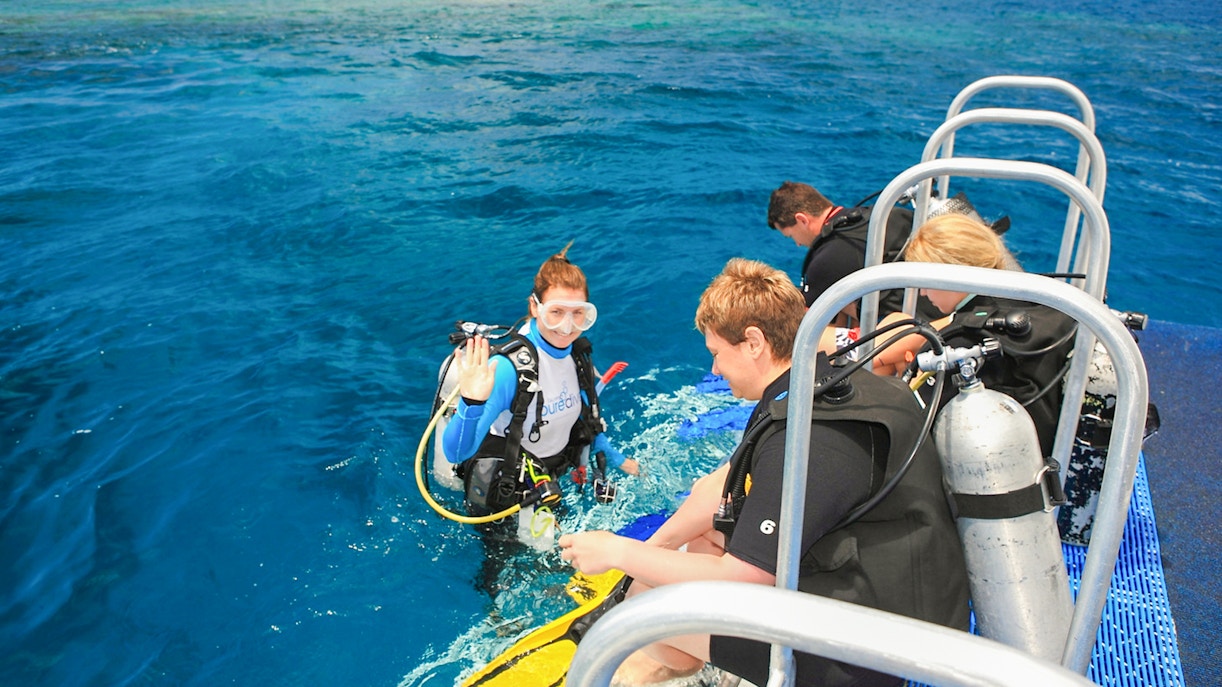 Catamaran sailing from Port Douglas to Low Isles with tourists preparing for guided snorkeling.