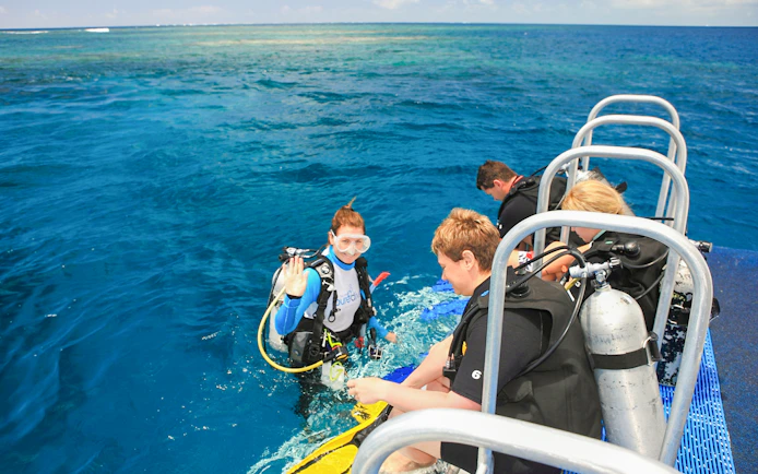 Snorkelers preparing to dive from a boat near Low Isles Island, Port Douglas.