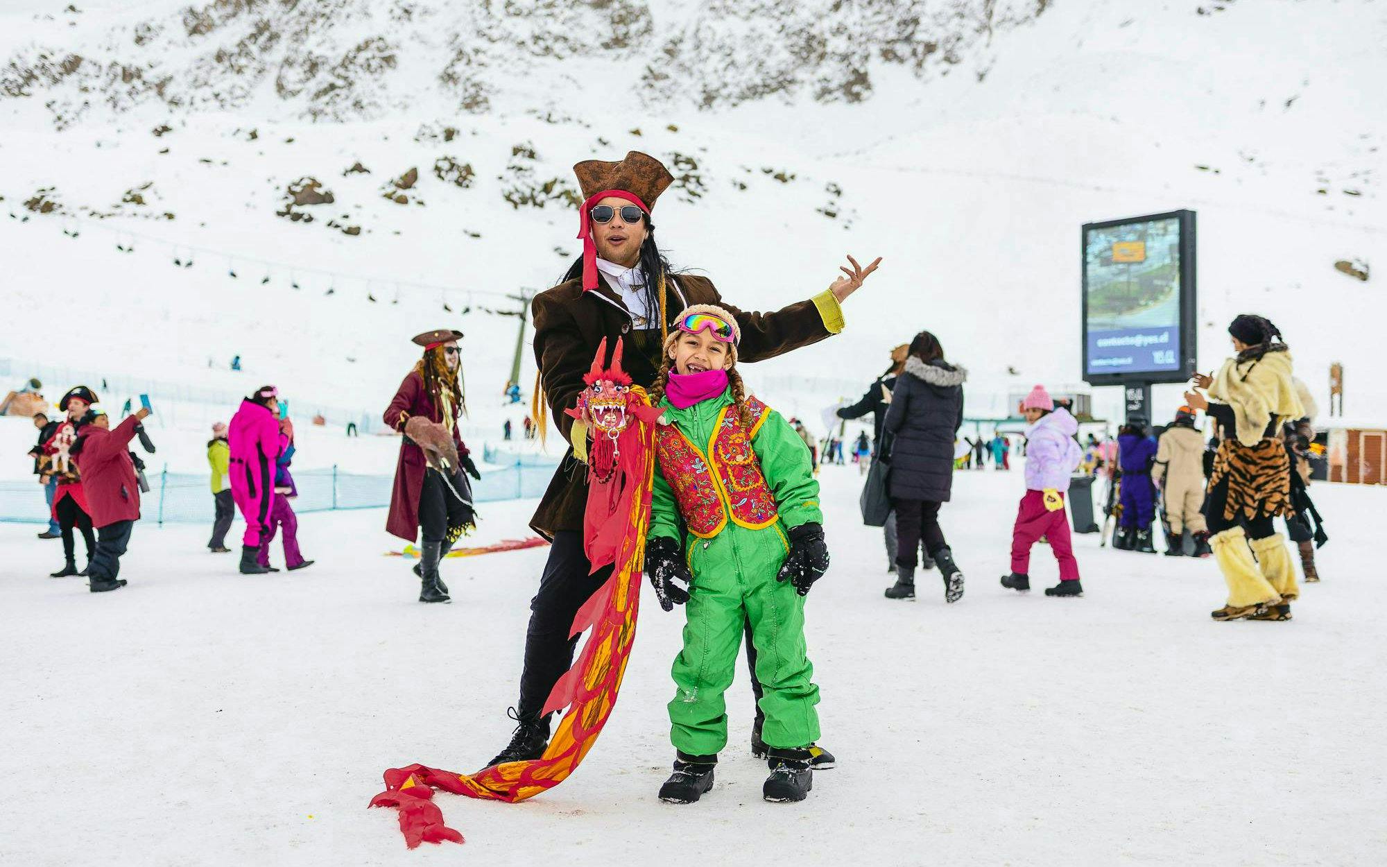 Tourists in costumes enjoying snow activities at Farellones Park.