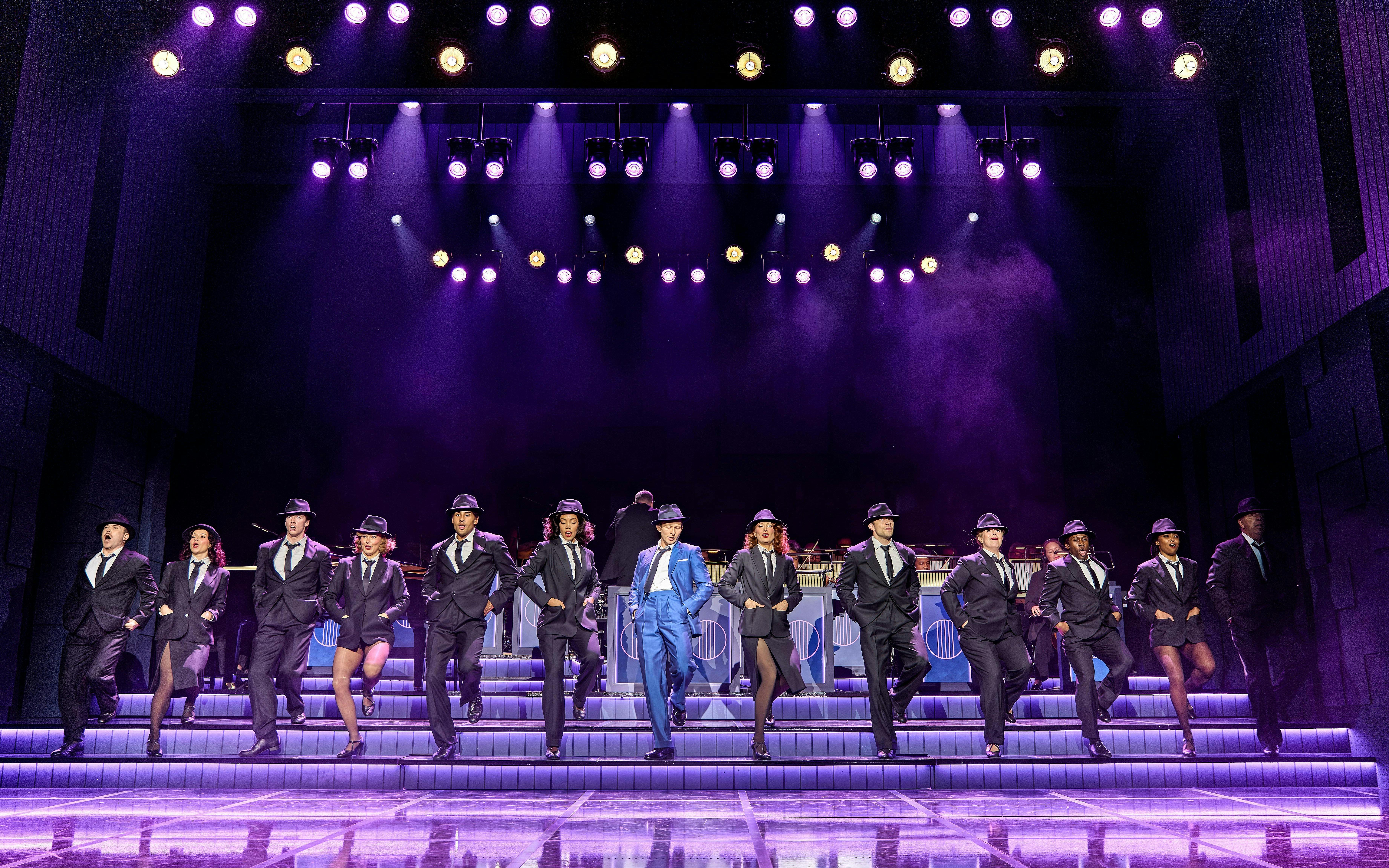 Performers in suits and hats dancing on stage in Sinatra The Musical, West End.