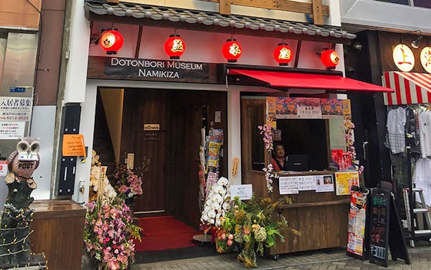 Entrance to Osaka Dotonbori Museum Namikiza with ticket booth and red lanterns.